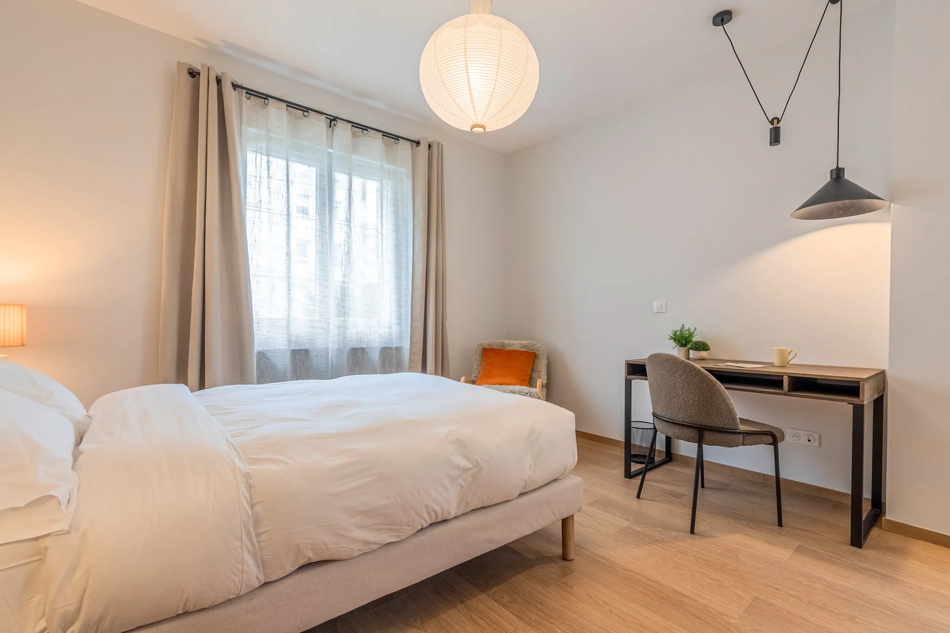 Photo d'une chambre standard — lit double, fenêtre, fauteuil et bureau